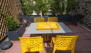 サン・マロにあるLe Courtoisville Apartmentの黄色のテーブルと椅子が並ぶパティオ
