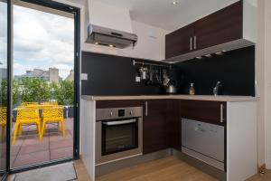 a kitchen with a stove top oven next to a balcony at Le Courtoisville Apartment in Saint Malo