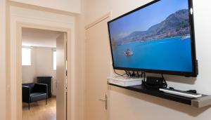 Le Courtoisville Apartment في سان مالو: تلفزيون بشاشة مسطحة على جدار في الغرفة