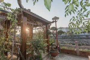 a wooden greenhouse in a garden with plants at Zen Tea House Seven Stars Park in Guilin