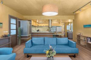 a living room with a blue couch and a kitchen at Luxury Pool House in Chania in Chania