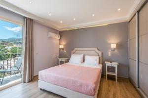 a bedroom with a bed and a balcony at Pansion Ermioni in Skala