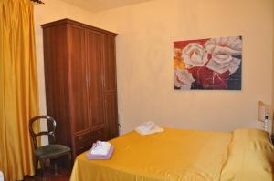 マッサローザにあるCasa Vacanze Graziaのベッドルーム1室(黄色いベッド1台、木製キャビネット付)