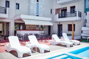 a group of white chairs and a swimming pool at Skiathos Somnia in Skiathos