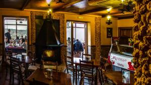 Un restaurante con mesas y sillas y chimenea. en Complejo Rural El Molinillo, en Arenas del Rey