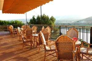 une rangée de tables et de chaises sur une terrasse dans l'établissement Complejo Rural El Molinillo, à Arenas del Rey