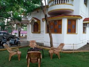 een groep stoelen en een tafel voor een huis bij GR Stays 4bhk Private Villa with Private Jacuzzi Pool BAGA in Baga