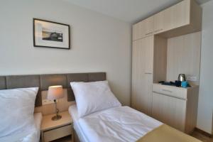 a small bedroom with two beds and a night stand at DW Koral in Niechorze