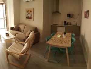 a small living room with a table and a couch at Apartmentos El Alfar del Sacramento in Toledo