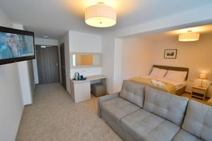 a living room with a couch and a bed and a television at DW Koral in Niechorze