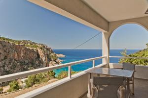 balcón con mesa y vistas al océano en Antikri villas en Kyra Panagia