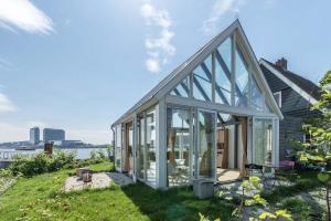 a glass house with a view of the water at The Panorama Suite (Mandelahuisje) in Amsterdam