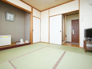 una sala de estar con una habitación grande con TV en Hotel Trend Saijo en Saijo