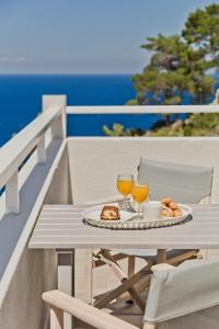 una mesa con un plato de comida y dos copas de vino en Antikri villas, en Kyra Panagia