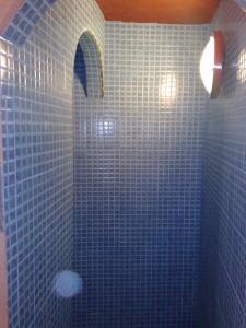 a blue tiled bathroom with a shower with blue tiles at Auberge Des Jardins du Dades in Boumalne