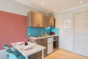 a kitchen with a white table and blue cabinets at Pansion Ermioni in Skala