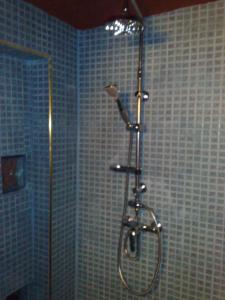 a shower in a bathroom with blue tiles at Auberge Des Jardins du Dades in Boumalne