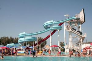 a water park with a water slide and people in the water at Hotel Annarita-mezza pensione plus- spiaggia inclusa in Rimini