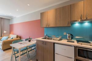 a kitchen and living room with a table and a counter top at Pansion Ermioni in Skala