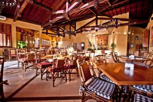 a restaurant with wooden tables and chairs and tables and chairs at Canto da Floresta Ecoresort in Amparo
