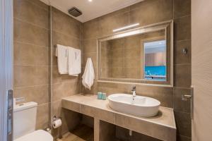 a bathroom with a sink and a toilet and a mirror at Pansion Ermioni in Skala +37 photos