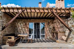 a wooden pergola on a patio with a table and chairs at Rosemarino Country House in Chornomorsk