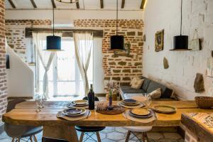 Rosemarino Country House في تشورنومورسك: غرفة طعام مع طاولة خشبية وأريكة
