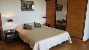 ピナールルにあるDomaine les Hauts de Capicciolaのベッドルーム1室(ベッド1台、ランプ付きテーブル付)