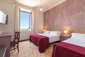 a hotel room with two beds and a window at Antica Villa in Gaeta