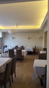 a dining room with white tables and chairs at DW Koral in Niechorze