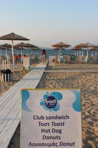 ein Schild am Strand mit Stühlen und Sonnenschirmen in der Unterkunft Garden Bungalow Valentina in Stavros