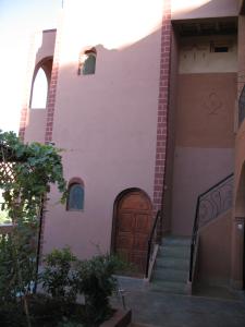 a building with a wooden door and stairs at Auberge Des Jardins du Dades in Boumalne