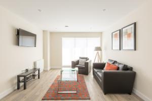 uma sala de estar com um sofá e uma mesa em House of Fisher- Solstice House Apartments em Farnborough