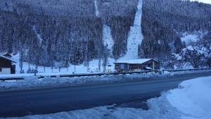 a house on the side of a snow covered road at Appart 4 pers proximité lac et remontées Le Praz - Arrayanes in Courchevel