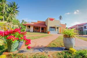 a house with two large flower pots in front of it at Sevenday Hotel in Marawila