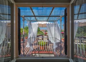 ein Fenster mit Blick auf einen Balkon mit Stühlen in der Unterkunft B&B 7 Rooms in Pisa