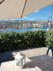 een tafel met een paraplu voor een waterlichaam bij Room Cvita in Trogir