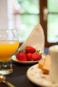 un plato de fresas y un vaso de zumo de naranja en Las Casonas de Avellaneda, en Navia