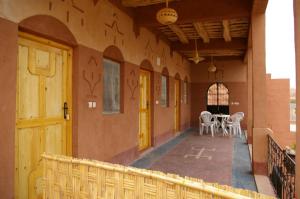 a hallway of a building with a table and chairs at Auberge Des Jardins du Dades in Boumalne
