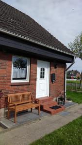 a wooden bench sitting outside of a brick house at Haus Spitzenblick in Friedrichskoog