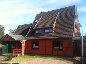 a red house with a gambrel roof at ton Timmermanns Hus in Prerow