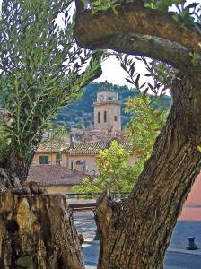 a view of a town with a clock tower at Le logis de la Fontaine in Ceyreste