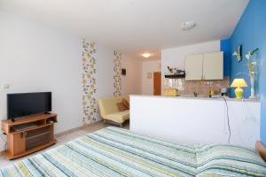 ein kleines Schlafzimmer mit einem Bett und einer Küche in der Unterkunft Apartments Antea in Rogoznica