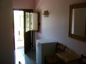 a room with a refrigerator and a mirror and a door at Agriturismo Zinedi in Pantelleria