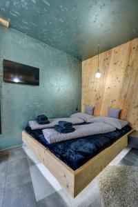 a bedroom with a large bed with a wooden wall at Apartmány ELISA in Šumperk