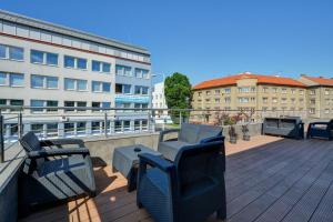 een balkon met stoelen en een tafel en gebouwen bij Apartmány ELISA in Šumperk