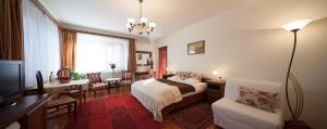 a bedroom with a bed and a table and a desk at Villa Cecile in Sopron