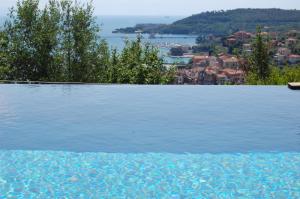 een zwembad met uitzicht op het water bij Miramare Apartments&Suites in La Spezia