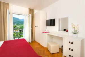 una camera da letto bianca con scrivania e finestra di B&B Aurora a Jelsa (Gelsa)