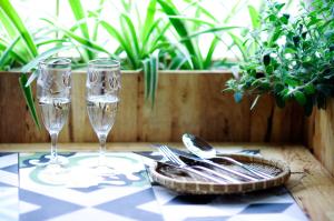 stół z dwoma kieliszkami i srebrem na stole w obiekcie Tuti Tong Dan Homestay w mieście Hanoi